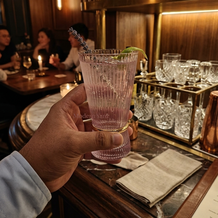 Hand holding Modern Yard pink ribbed glass tumbler